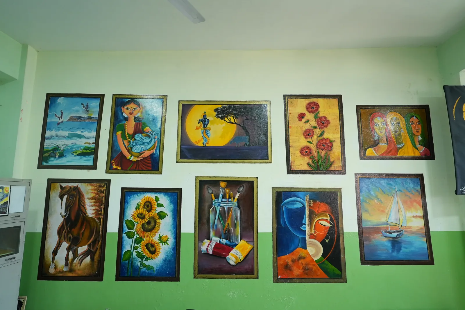 Framed student paintings on wall